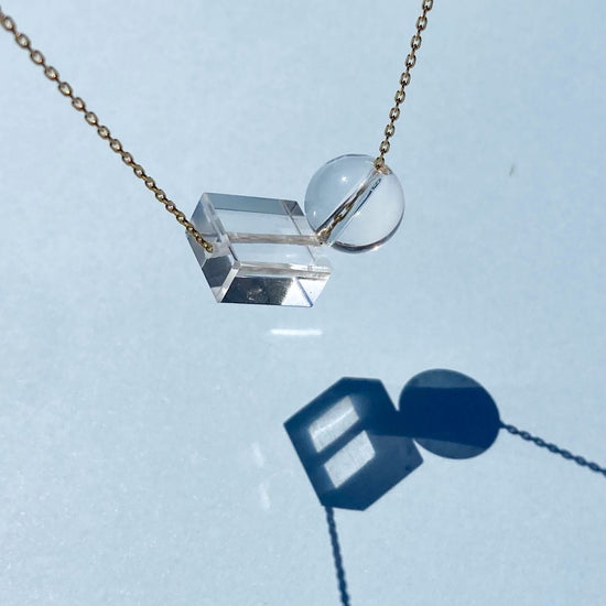 close up of clear crystal quartz bead necklace on blue background