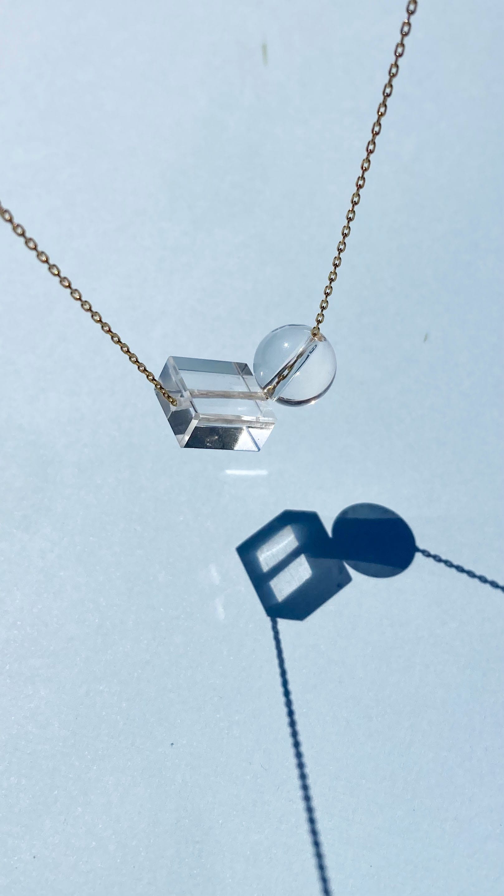 close up of clear crystal quartz bead necklace on blue background